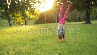 <strong>小</strong>女孩在绿色的草地上玩，同时做一个杂技<strong>轮</strong>。 年轻的<strong>运动小</strong>子有一个非常好的心情。